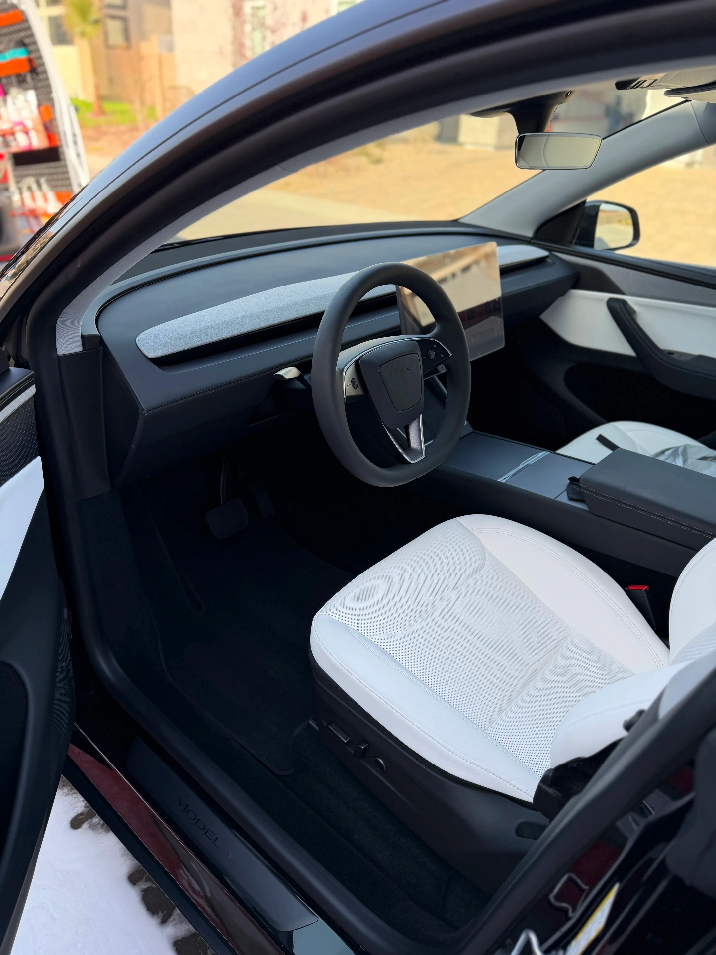 Clean Tesla Model 3 interior with white seats and spotless dashboard